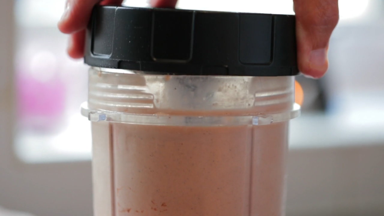 Osoba zatvara blender sa pripremljenim proteinskim napitkom