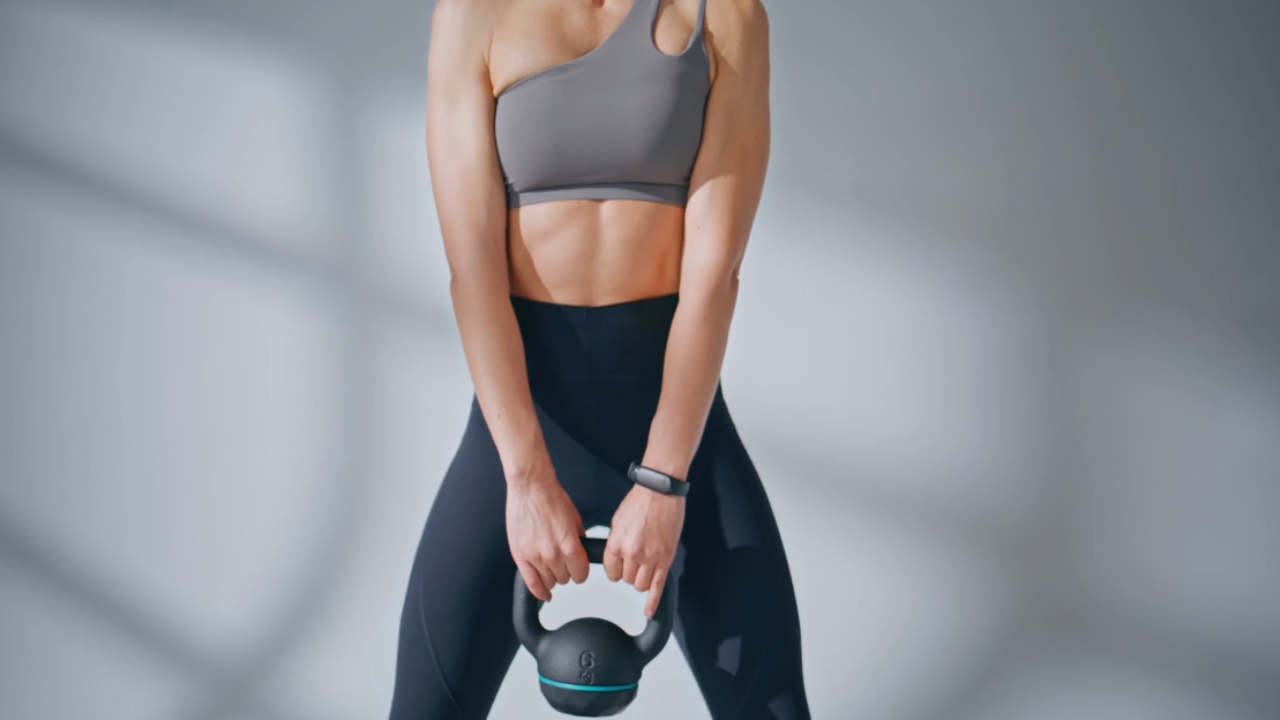 Žena drži kettlebell tokom treninga snage